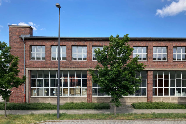 Industriegebäude aus rotem Backstein mit einer Fensterfront, das als Brauerei für handgemachten Kombucha dient