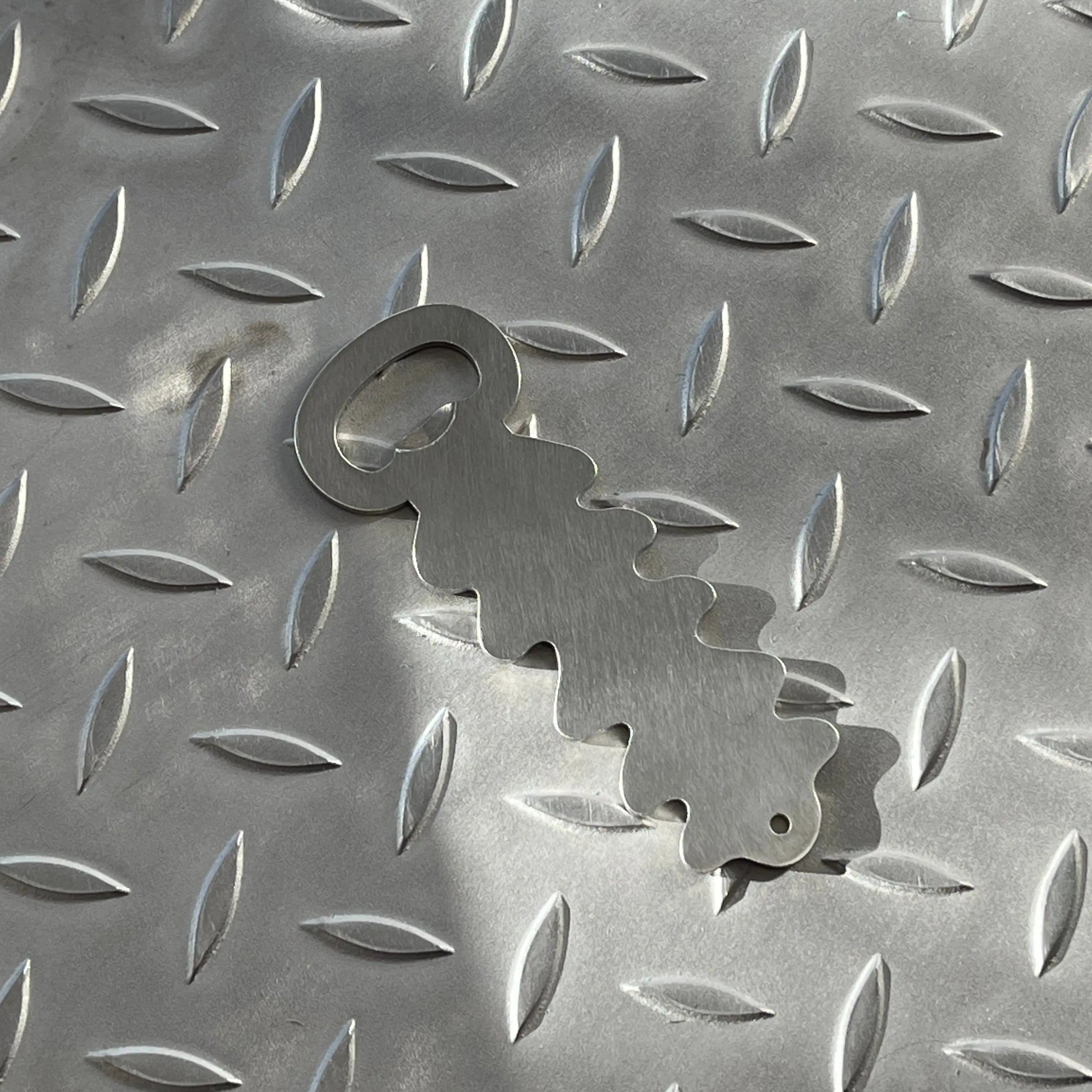 BOUCHE Flaschenöffner aus Metall auf strukturierter Oberfläche, Nahaufnahme